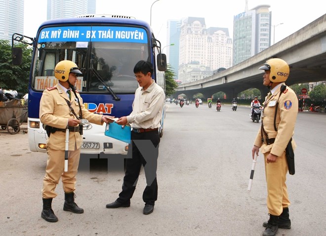 Lực lượng Cảnh sát giao thông kiểm tra phương tiện xe khách. (Ảnh: TTXVN)