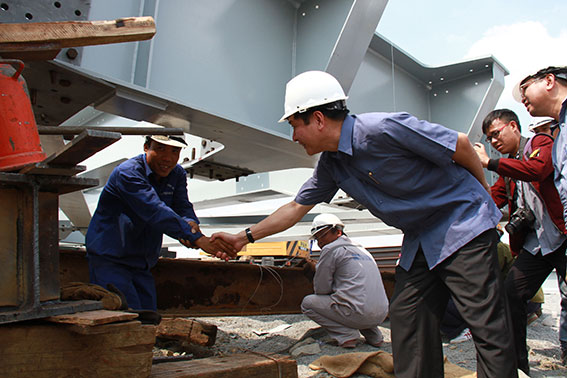 Đồng chí Bùi Văn Cường bắt tay động viên công nhân thi công các nhịp Cầu Ghềnh.    