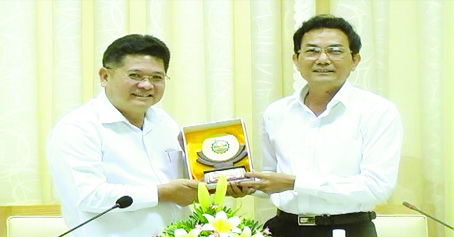 Phó chủ tịch UBND tỉnh Võ Văn Chánh (phải) tặng logo biểu trưng của tỉnh cho ông Montri Suwaposi, Tổng giám đốc Công ty cổ phần chăn nuôi C.P. Việt Nam.