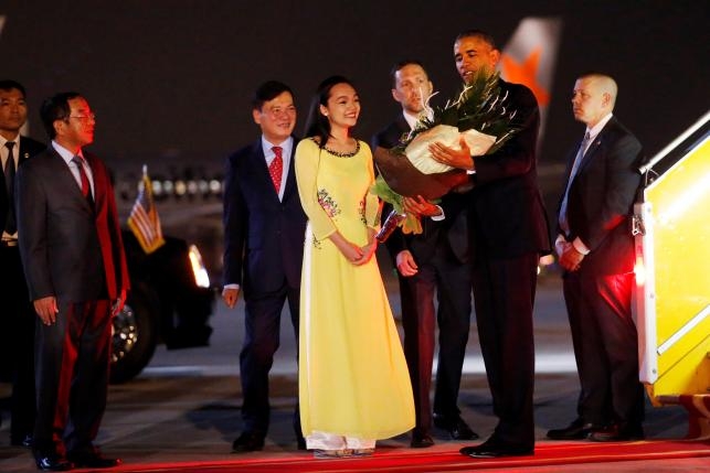 Tổng thống Obama nhận đóa hoa chào mừng. Ảnh: Reuters