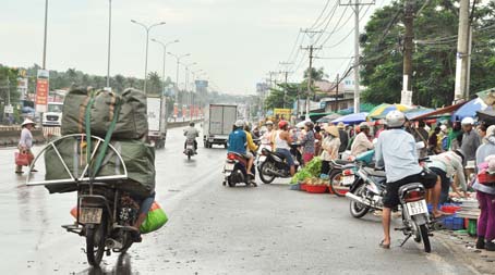Chợ công nhân lấn đường trên quốc lộ 51, đoạn qua Công ty TNHH Cự Thành (xã An Phước, huyện Long Thành).