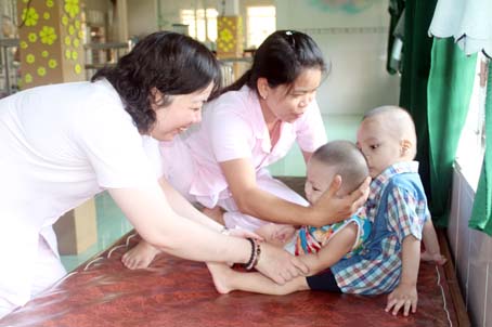 Viên chức Trung tâm nuôi dưỡng trẻ mồ côi, khuyết tật tỉnh chơi đùa với trẻ mồ côi, khuyết tật. Ảnh: N.SƠN