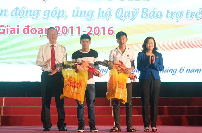 Phó chủ tịch UBND tỉnh Nguyễn Hòa Hiệp (bìa phải) và Giám đốc Sở Lao động - thương binh và xã hội Huỳnh Văn Tịnh (bìa trái) tặng học bổng và quà cho các cá nhân tham gia giao lưu