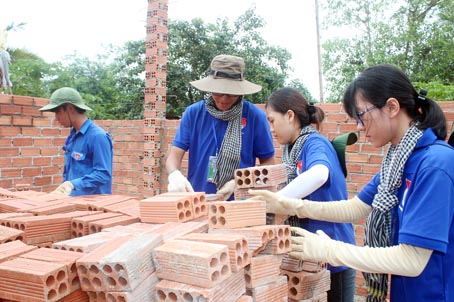Các chiến sĩ thanh niên tình nguyện Trường đại học Lạc Hồng đang phụ xây ngôi nhà mơ ước cho gia đình ông Xì A Sáng (ấp 4, xã Vĩnh Tân, huyện Vĩnh Cửu).