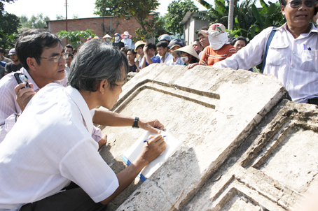 Nhóm khảo cổ ghi chép lại văn bia mộ cổ Cầu Xéo (ảnh trái).