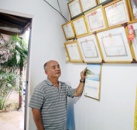 Ông Trần Mộng Thành bên những kỷ niệm chương cùng bằng khen, giấy khen do các cấp chính quyền trao tặng.