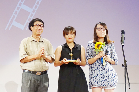 Đạo diễn Nguyễn Hữu Phần (bìa trái) trao giải Búp sen vàng phim truyện xuất sắc do Ban giám khảo bình chọn cho đoàn làm phim XX2016.