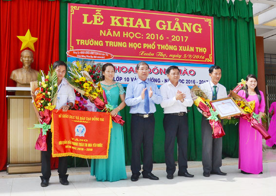 Phó chủ tịch UBND tinh Nguyễn Quốc Hùng (thứ 3 từ trái qua) tặng danh hiệu tập thể xuất sắc năm học 2015-2016 cho Trường trung học phổ thông Xuân Thọ