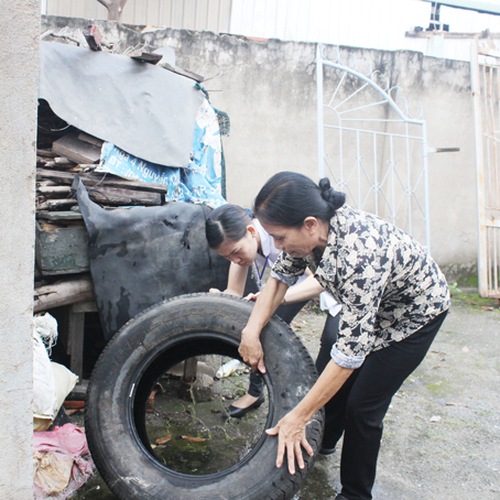   Cộng tác viên y tế phường Trảng Dài (TP.Biên Hòa) đổ nước trong vỏ bánh xe cũ để trong nhà dân phòng ngừa muỗi phát sinh.