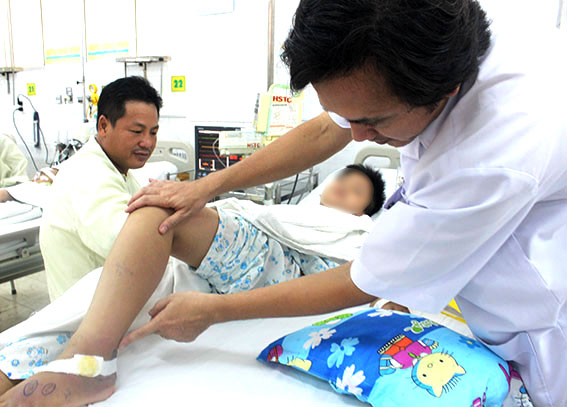 Bác sĩ Đặng Công Chánh, Phó trưởng khoa Hồi sức tích cực - chống độc, Bệnh viện nhi đồng Đồng Nai khám lại vết thương cho bé Nguyễn Hoàng Hiệp. 