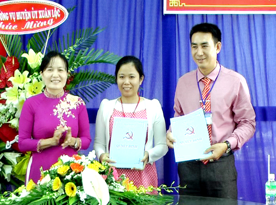 Bà Nguyễn Thị Cát Tiên, Phó bí thư thường trực Huyện ủy Xuân Lộc trao quyết định cho llãnh đạo nhà trường
