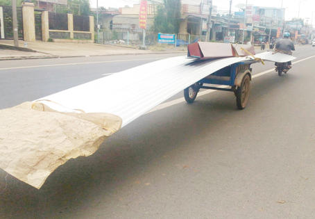 Chiếc xe lôi tự chế chở tôn dài hàng chục mét lưu thông trên quốc lộ 20, đoạn thuộc ấp Bạch Lâm, xã Gia Tân 2 (huyện Thống Nhất, ảnh chụp ngày 26-9-2016). Ảnh: H.Nguyên