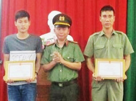 Đại tá Trần Tiến Đạt, Trưởng công an TP.Biên Hòa, trao giấy khen của Giám đốc Công an tỉnh cho anh Đặng Quốc Thân (bìa phải).