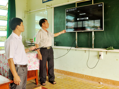 Ông Vương Mạnh Thế (phải) cùng Phó hiệu trưởng Nguyễn Duy Bằng kiểm tra tivi tại mỗi lớp.