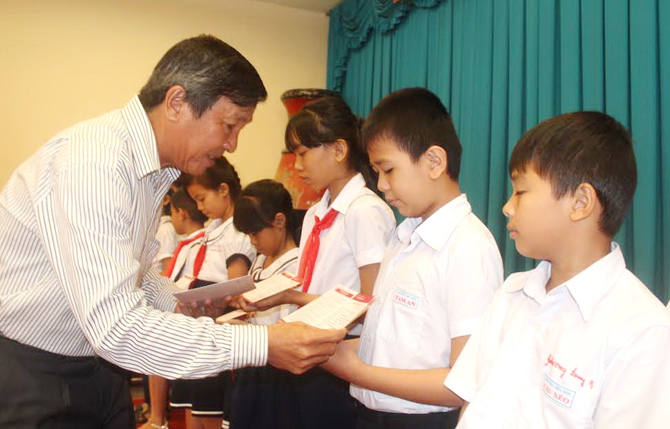 Đồng chí Hồ Thanh Sơn, UV Ban TVTU, Trưởng ban Dân vận Tỉnh ủy trao sổ tiết kiệm cho học sinh nhận học bổng
