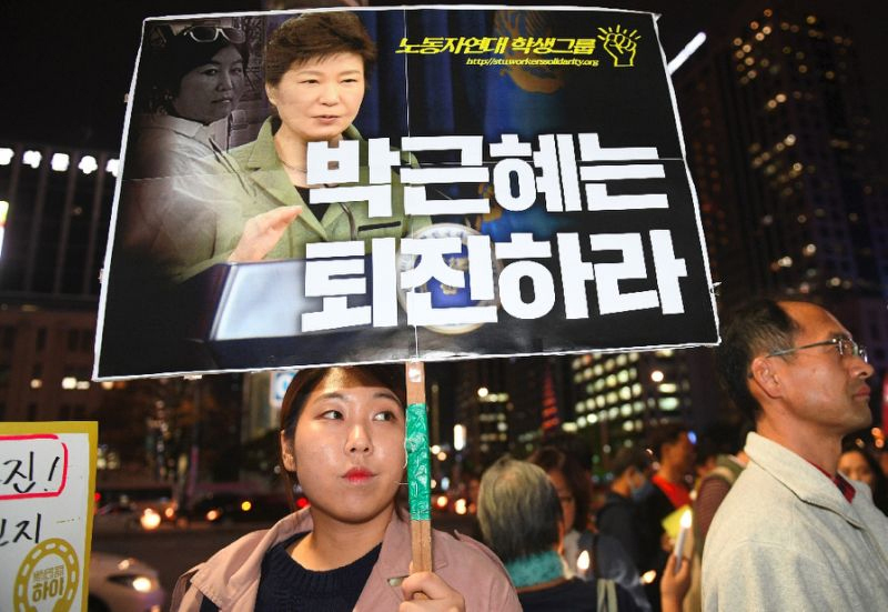Một người cầm bức chân dung của Tổng thống Hàn Quốc Park Geun-Hye và bà Choi Soon-sil trong một cuộc biểu tình tại Seoul - Nguồn AFP