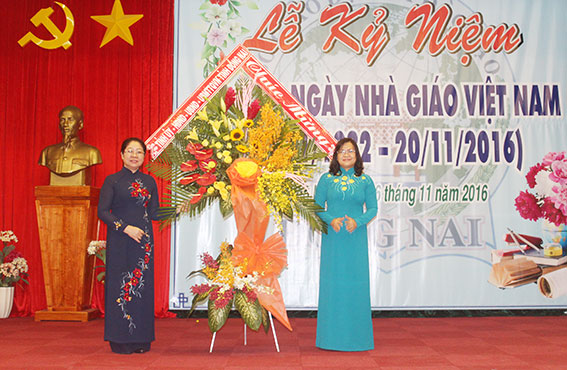 Đồng chí Nguyễn Hòa Hiệp (bìa phải), Phó chủ tịch UBND tỉnh tặng hoa chúc mừng cho đại diện ngành giáo dục - đào tạo tỉnh