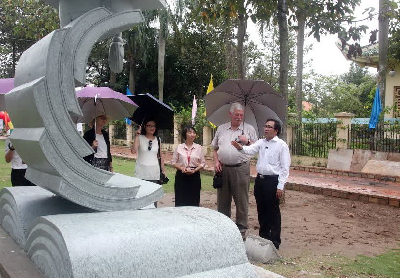 ông Trần Đăng Ninh, Giám đốc Trung tâm Văn miếu Trấn Biên (bìa phải) đang giới thiệu với một số khách ngoại quốc đến tham quan Vườn tượng nghệ thuật trong sáng 17-11