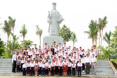 Học sinh nhận học bổng Vượt khó vì tương lai năm 2015 chụp hình cùng các đại biểu tại tượng vua Lý Thái Tổ ở Văn miếu Trấn Biên. Ảnh: Huy Anh
