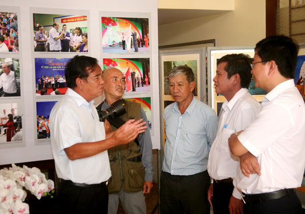 Đồng chí Trần Đình Thành, nguyên Bí thư Tỉnh ủy (ngoài cùng bên trái) trao đổi cùng hội viên Câu lạc bộ Nhiếp ảnh Hội Nhà báo Đồng Nai và khách mời khi đến tham quan triển lãm.