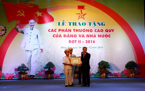 Đồng chí Đinh Quốc Thái, Chủ tịch UBND tỉnh thừa ủy quyền trao Huy chương chống Mỹ của Thủ tướng Chính phủ nước CHDCND Lào cho một cá nhân của tỉnh.