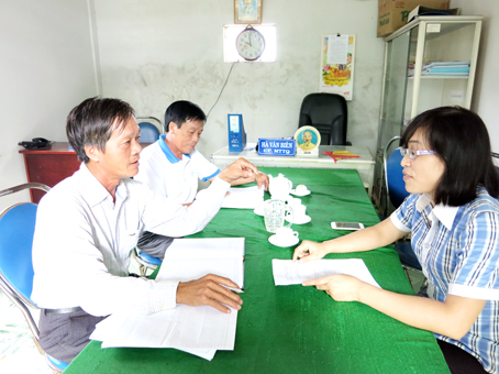 Ông Nguyễn Thế Huỳnh (trái) đang trao đổi công tác vận động nhân dân với lãnh đạo Ủy ban MTTQ xã Đồi 61.