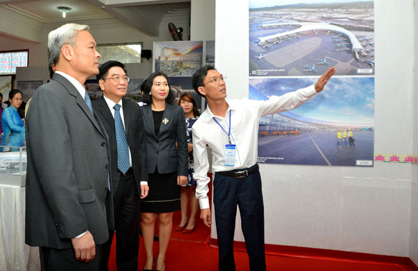 Bí thư Tỉnh uỷ Nguyễn Phú Cường (bên trái) đang nghe giới thiệu về các mẫu thiết kế sân bay tại buổi trưng bày.