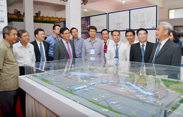 Bí thư Tỉnh uỷ Nguyễn Phú Cường (bên phải) đang trao đổi về thiết kế sân bay tại buổi trưng bày.