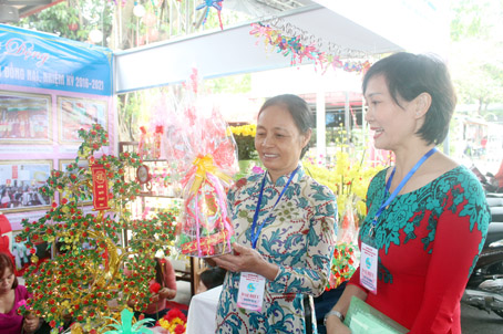 Bà Nguyễn Thị Là (trái) tham quan gian hàng trưng bày sản phẩm sáng tạo của các cấp Hội phụ nữ huyện Long Thành tại Đại hội đại biểu phụ nữ tỉnh lần thứ IX chiều 28-12.
