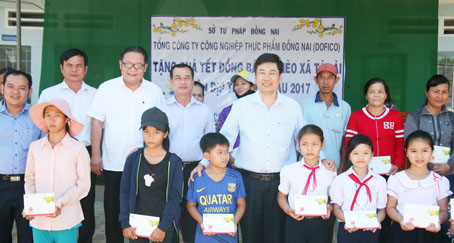 Các thành viên trong đoàn tặng quà, chụp ảnh lưu niệm cùng người dân được nhận quà tết ở xã Tà Lài, huyện Tân Phú. Ảnh: V.Truyên