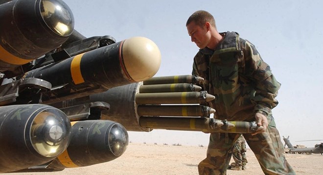 Binh sỹ Mỹ gắn tên lửa lên trực thăng tấn công Apache. (Nguồn: AFP)