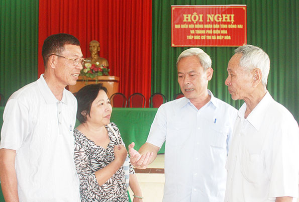 Đồng chí Nguyễn Phú Cường (thứ 2 từ trái sang), Bí thư Tỉnh ủy, Chủ tịch HĐND tỉnh trao đổi thêm với cử tri xã Hiệp Hòa sau hội nghị.