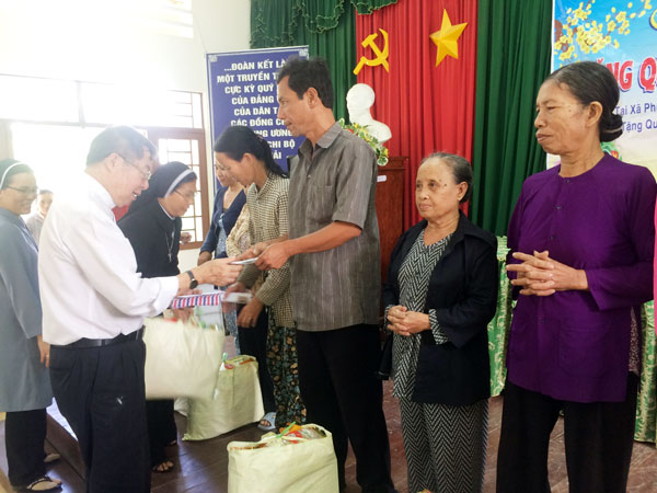 Chủ tịch Ủy ban Đoàn kết Công giáo tỉnh Trần Xuân Thảo (bìa trái) trao quà tết cho đồng bào có hoàn cảnh nghèo tại xã Phú Xuân, huyện Tân Phú.
