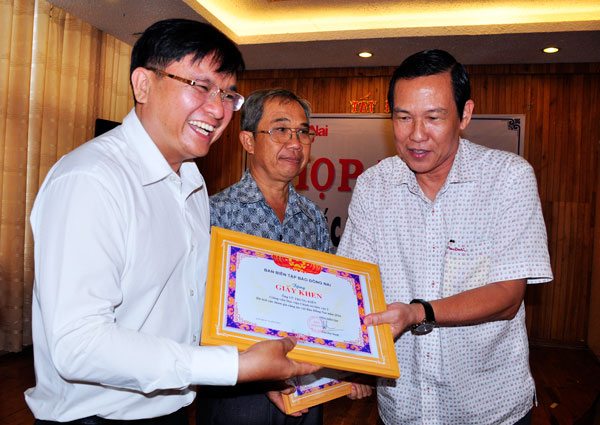 Phó tổng biên tập Báo Đồng Nai Lã Xuân Phú trao giấy khen cho cộng tác viên Vũ Trung Kiên.