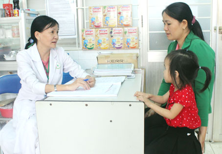 Bác sĩ Bệnh viện nhi đồng Đồng Nai khám dinh dưỡng cho một trẻ em. Ảnh: A.An