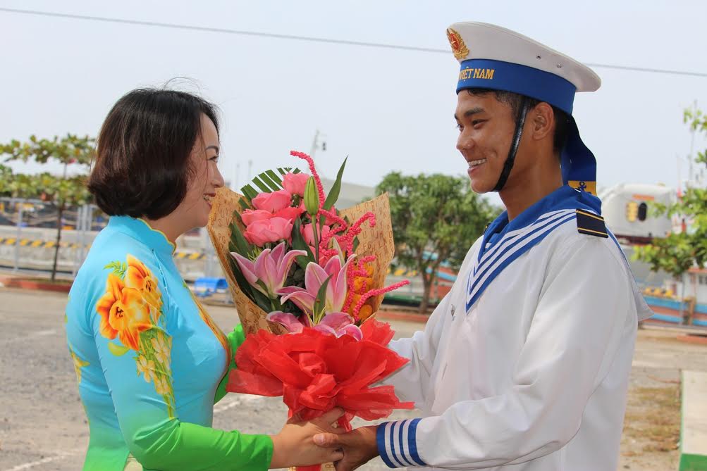 Chị Hà Thị Kim Cúc, tặng hoa, động viên cháu Phạm Văn Đạt trước giờ theo tàu đi làm nhiệm vụ