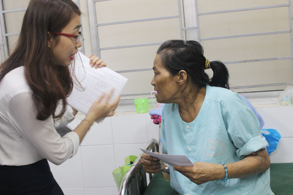 Nhân viên Phòng công tác xã hội Bệnh viện đa khoa Thống Nhất trao quà cho bà Thoóng Cóng Mùi, bệnh nhân bị suy thận mạn.