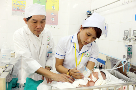 Bác sĩ Vũ Công Tầm, Trưởng khoa Phẫu thuật gây mê - hồi sức Bệnh viện nhi đồng Đồng Nai thăm một bệnh nhân sơ sinh sau khi được phẫu thuật thành công gan ngoài ổ bụng.