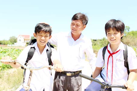 Trưởng ấp Nguyễn Văn Ngoan (đứng giữa) và các học sinh trên con đường nội đồng Phú Tân - Võ Dõng.