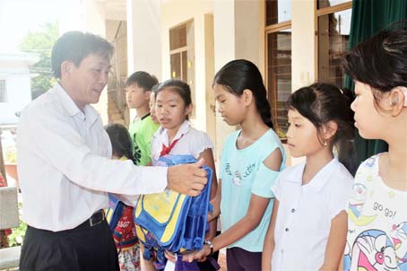 Ông Hoàng Văn Long, Quyền Giám đốc Quỹ Bảo trợ trẻ em tỉnh, tặng dụng cụ học tập cho học sinh.