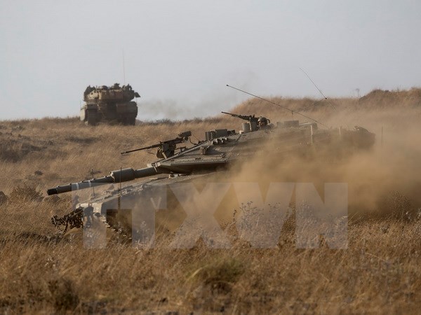 Xe tăng Merkava của Israel trong buổi diễn tập bắn đạn thật trên Cao nguyên Golan. (Nguồn: EPA/TTXVN)