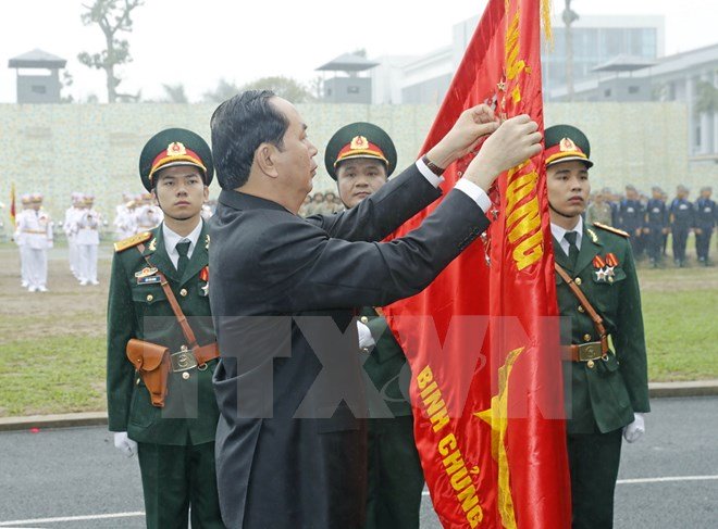 Chủ tịch nước gắn huân chương Quân công hạng nhất lên lá cờ truyền thống của Bộ Tư lệnh Binh chủng Đặc công. Ảnh: TTXVN