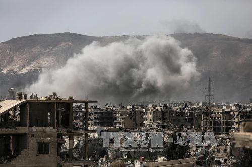 Khói bốc lên sau các cuộc không kích xuống quận Jobar, ngoại ô Damascus, ngày 19/3. Ảnh: AFP/TTXVN 