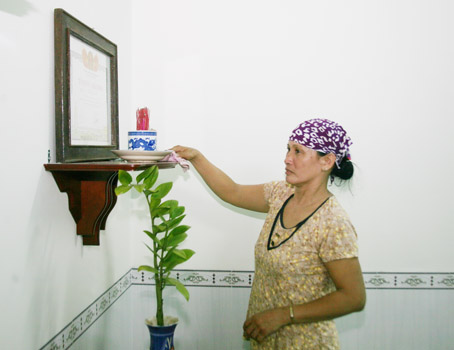Bà Trần Thị Thanh Hoa (ngụ ấp 5, xã Lộ 25, huyện Thống Nhất) bên bàn thờ của người cha liệt sĩ trong căn nhà mới khang trang.