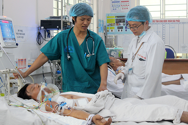 Các bác sĩ trong ê kíp cấp cứu đang tái khám cho bệnh nhân Lâm đang điều trị tại Khoa Hồi sức – hậu phẫu, Bệnh viện đa khoa Thống Nhất. Ảnh: Đặng Ngọc.