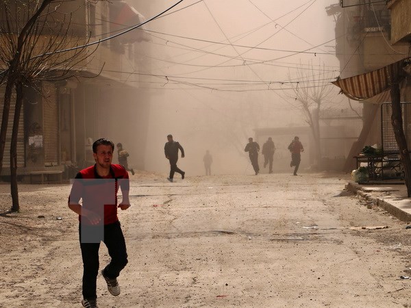 Người dân Syria tìm nơi ẩn náu trong một đợt không kích ở Ain Tarma, thuộc khu vực Đông Ghouta. (Nguồn: AFP/TTXVN)