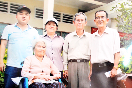 Bà Lưu Kim Ngọc (đội mũ) trao xe lăn cho người tàn tật.