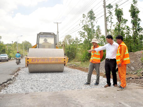Ông Đỗ Văn Thắng, Đội trưởng Đội Duy tu sửa chữa cầu đường Công ty TNHH Bá Lộc (giữa) cùng công nhân kiểm tra đoạn đường đang được sửa.