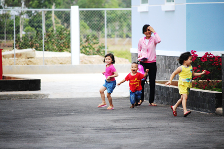 Trẻ em chơi vui dưới sân nhà ở công vụ.