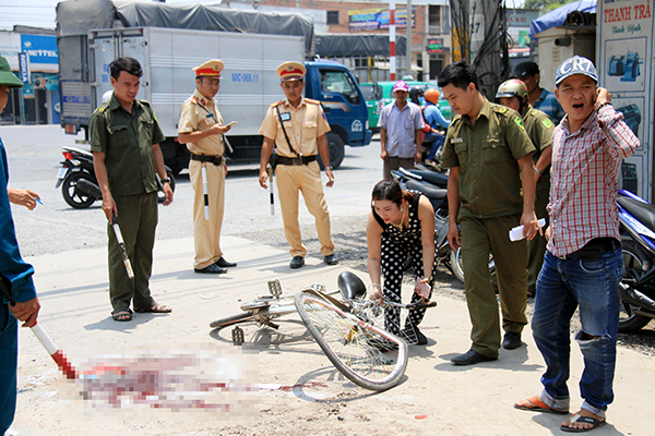 Một người phụ nữ giúp Cảnh sát giao thông lập lại hiện trường vụ tai nạn ban đầu.